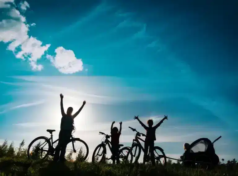 Famille à vélo sur une colline en contre jour
