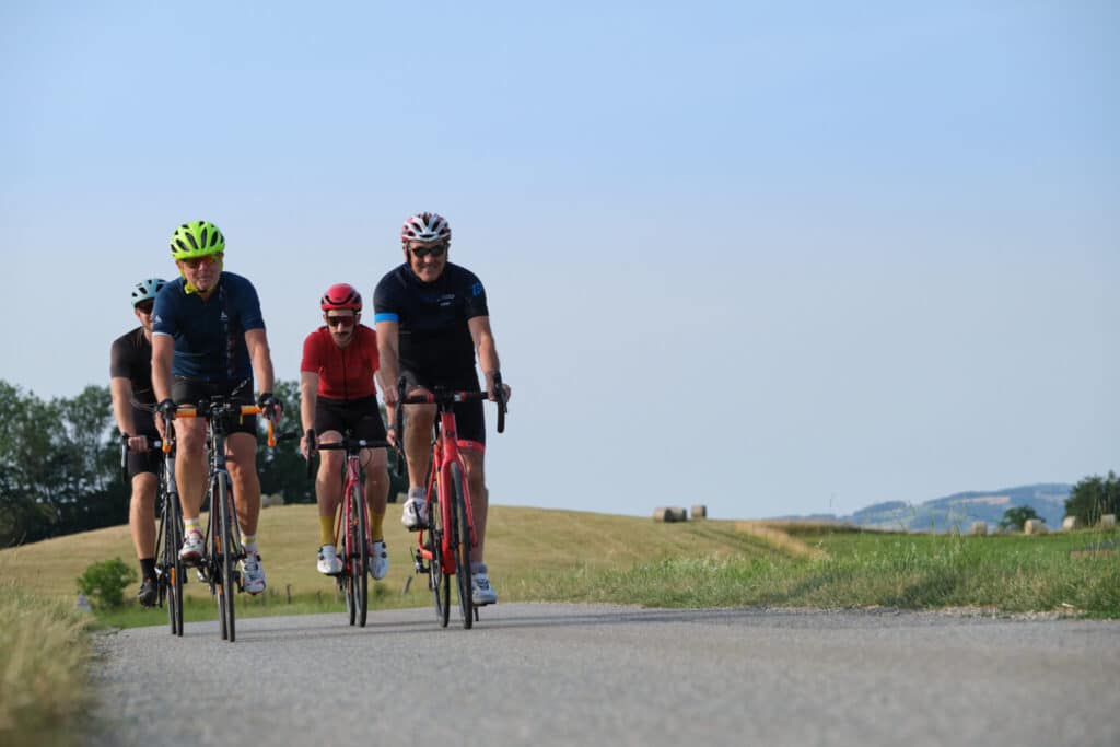 4 cyclistes d'âges variés sur une route de campagne