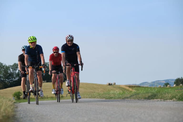 4 cyclistes d'âges variés sur une route de campagne