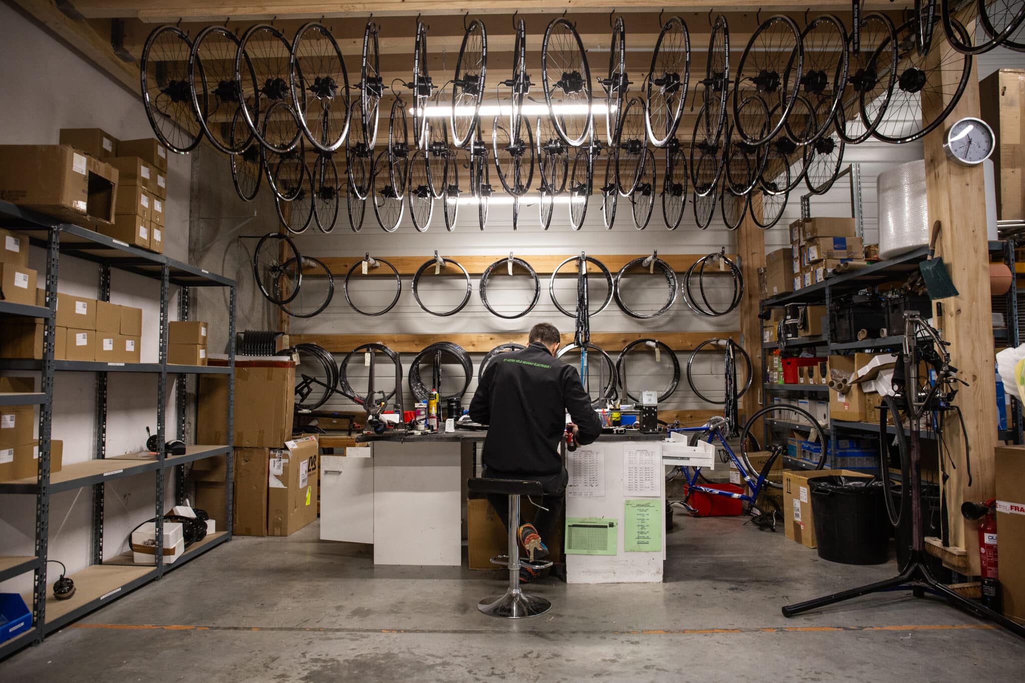 Technicien Annad rayonnant une roue de vélo dans l'atelier