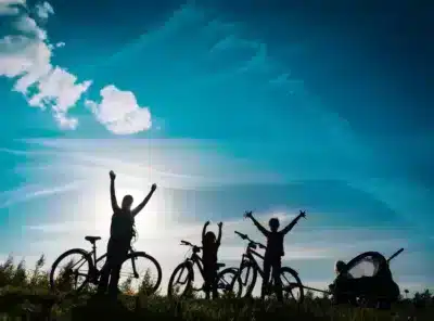 Famille à vélo sur une colline en contre jour