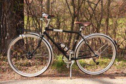 Vélo vintage chromé sur fond de nature, électrification invisible dans la roue avant.