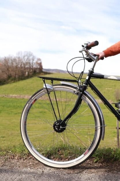 Gros plan sur la roue avant d'un vélo de ville vintage équipé d'un moteur ULTRA roua avant fonctionnant en Bluetooth.